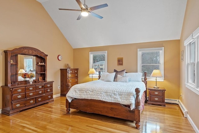 bedroom with light wood finished floors, baseboards, a ceiling fan, a baseboard radiator, and high vaulted ceiling