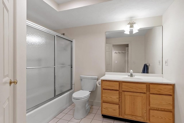 full bath with vanity, shower / bath combination with glass door, tile patterned flooring, and toilet