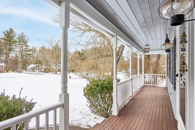 snow covered deck with a porch