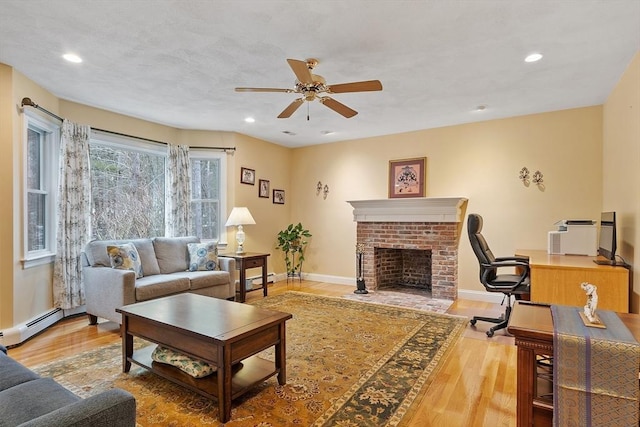 living room with a fireplace, a baseboard heating unit, wood finished floors, and recessed lighting