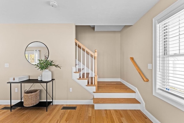 stairs with hardwood / wood-style flooring and a wealth of natural light