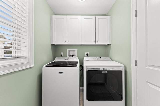 laundry room with washing machine and dryer and cabinets