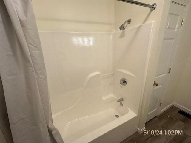 bathroom featuring hardwood / wood-style floors and shower / bath combo with shower curtain