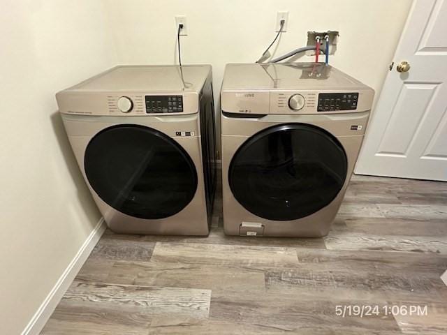 clothes washing area featuring independent washer and dryer and light hardwood / wood-style floors