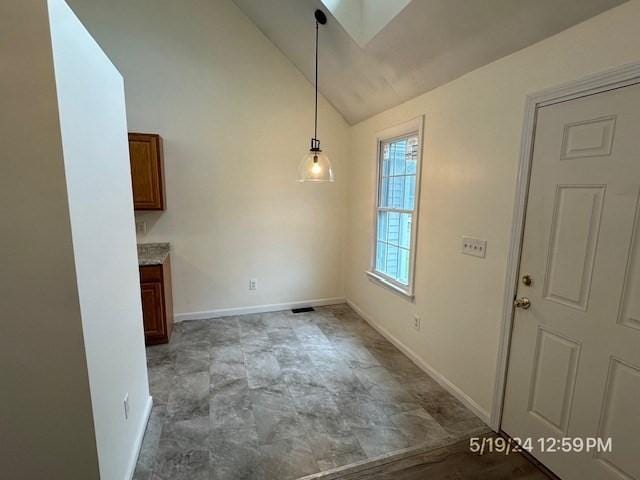 unfurnished dining area with vaulted ceiling with skylight