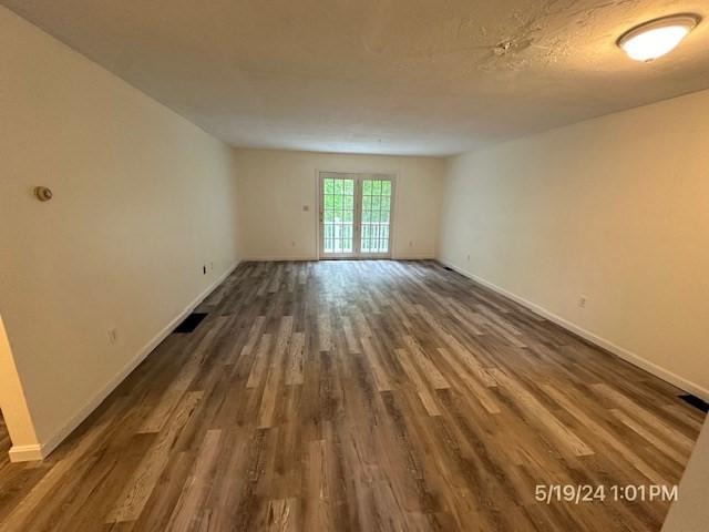 unfurnished room with dark wood-type flooring