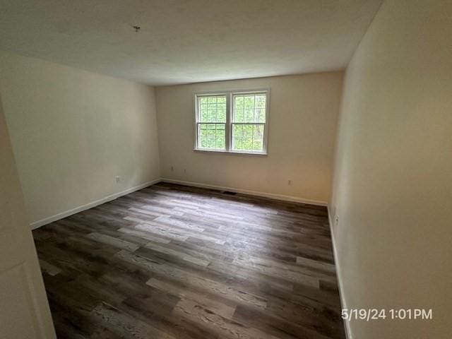 spare room featuring dark wood-type flooring