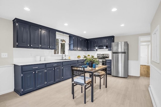 kitchen featuring a baseboard heating unit, blue cabinets, sink, light hardwood / wood-style flooring, and appliances with stainless steel finishes