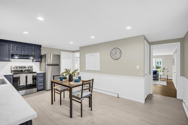 kitchen featuring light hardwood / wood-style floors, a baseboard heating unit, and appliances with stainless steel finishes