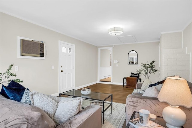 living room featuring hardwood / wood-style floors, a wall unit AC, and ornamental molding