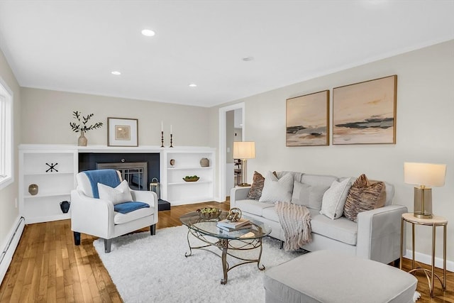 living room with a baseboard heating unit and hardwood / wood-style flooring