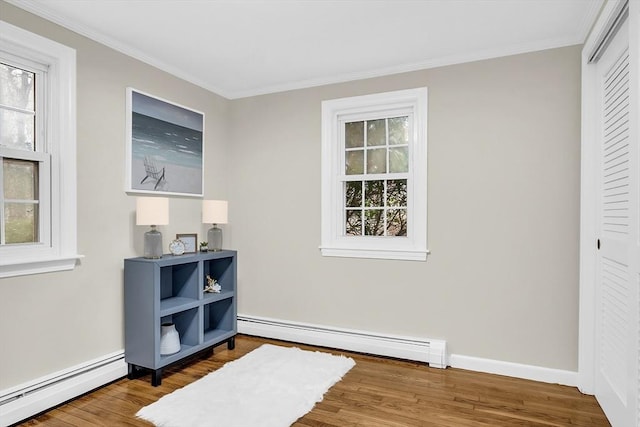 living area featuring a healthy amount of sunlight and a baseboard heating unit