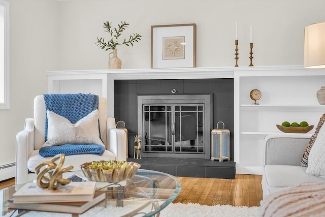 living room featuring hardwood / wood-style flooring and a tiled fireplace