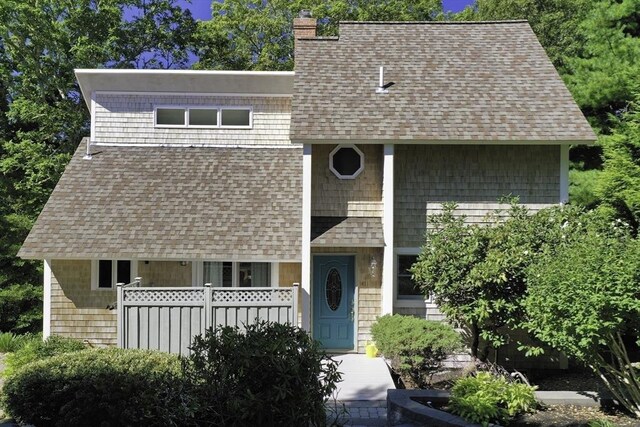 view of front of house featuring a shingled roof and a chimney