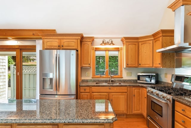 kitchen with a wealth of natural light, sink, appliances with stainless steel finishes, and wall chimney exhaust hood