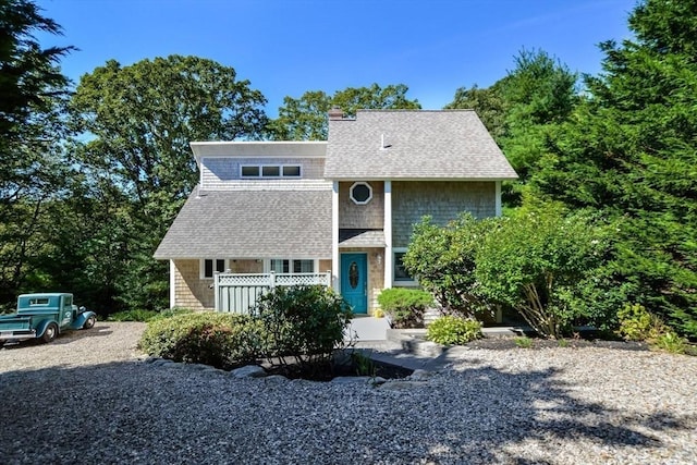 view of front of home featuring a chimney and a shingled roof