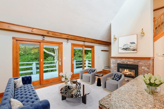 living area with baseboard heating, wood finished floors, and a brick fireplace