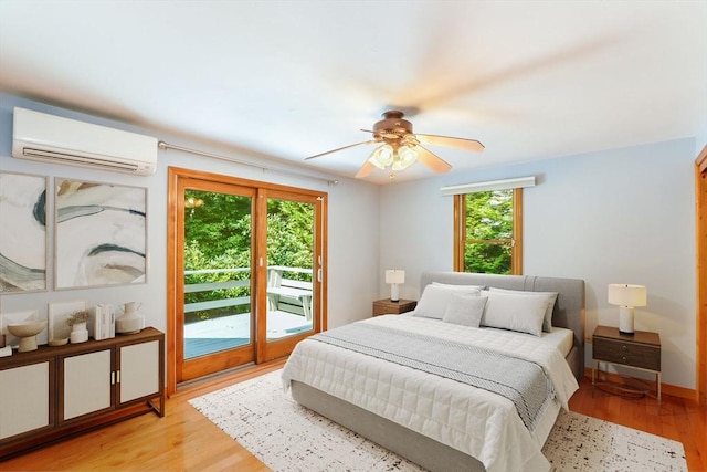 bedroom with an AC wall unit, access to outside, light wood-style floors, and a ceiling fan