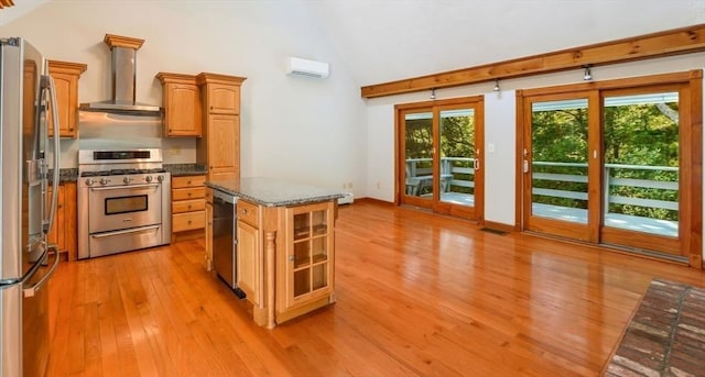 kitchen with a wall mounted air conditioner, wall chimney range hood, light wood-style floors, vaulted ceiling, and stainless steel appliances