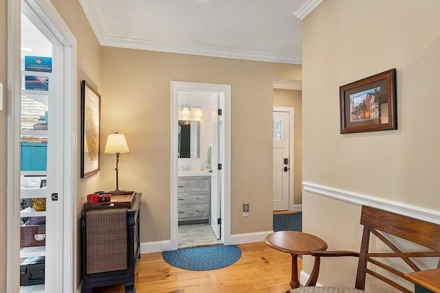 hallway with crown molding, baseboards, and wood finished floors