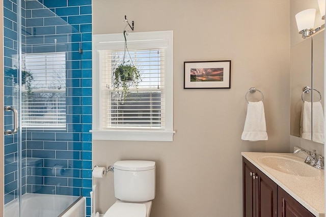 bathroom featuring vanity, toilet, and shower / bath combination with glass door