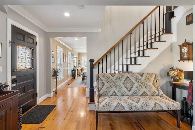 entryway featuring stairway, baseboards, ornamental molding, and hardwood / wood-style flooring