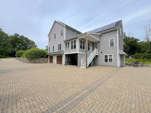 364 Chestnut Hill Rd, Millville, MA 01529 - view of side of home featuring a garage, roof mounted solar panels, stairs, and decorative driveway