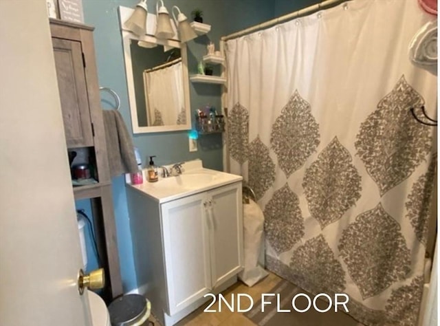 bathroom with a shower with curtain, wood-type flooring, and vanity