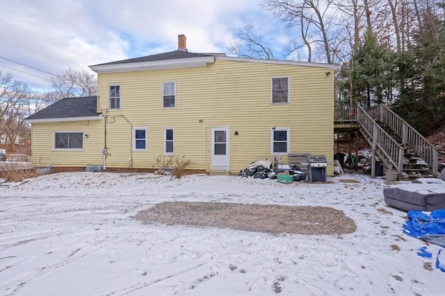 snow covered rear of property featuring a wooden deck