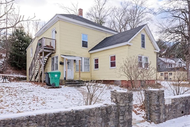 view of snow covered back of property