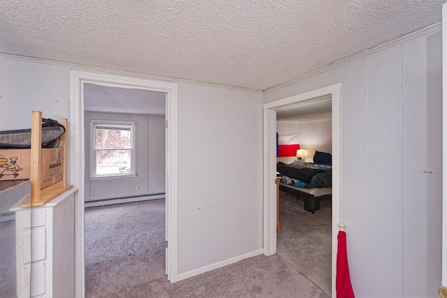 hallway with light colored carpet, a textured ceiling, and a baseboard heating unit