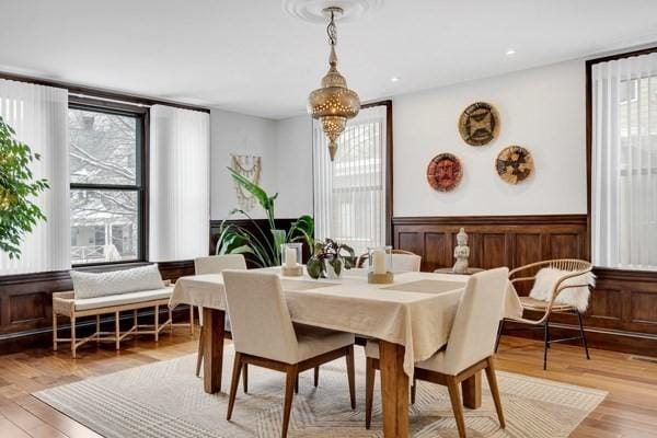 dining area with a healthy amount of sunlight, light hardwood / wood-style floors, and a notable chandelier