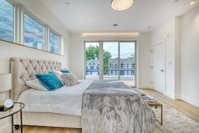 bedroom with access to outside and light wood-type flooring