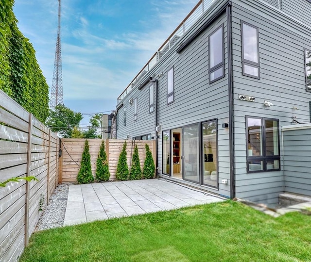 rear view of house with a lawn and a patio