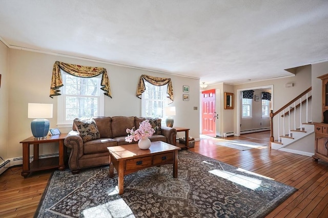 living room featuring baseboards, stairway, hardwood / wood-style floors, baseboard heating, and crown molding