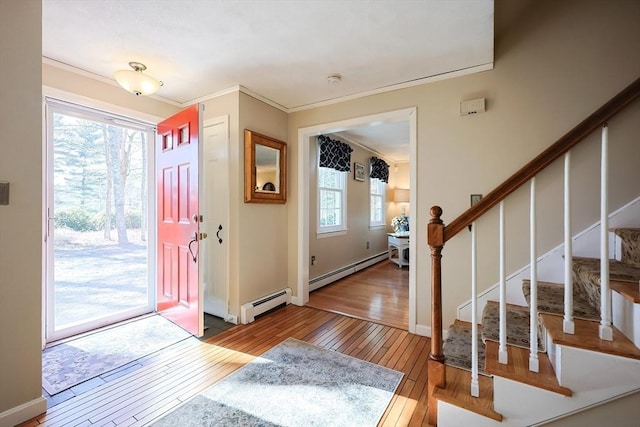 entrance foyer with stairs, ornamental molding, a baseboard radiator, and hardwood / wood-style flooring