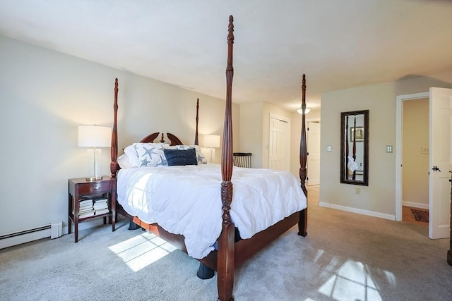 carpeted bedroom with a baseboard heating unit, a closet, and baseboards