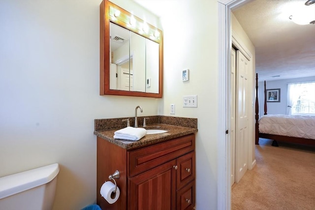 ensuite bathroom with visible vents, toilet, vanity, and ensuite bathroom