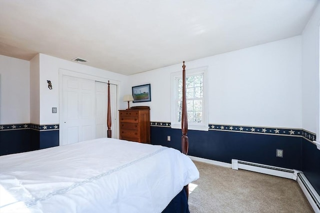 bedroom with baseboard heating, carpet, a closet, and visible vents