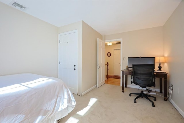 bedroom with light colored carpet, visible vents, and baseboards