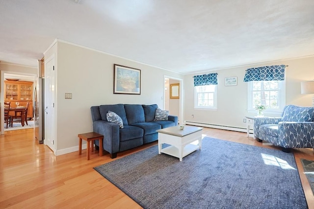 living room featuring light wood finished floors, baseboards, baseboard heating, and crown molding