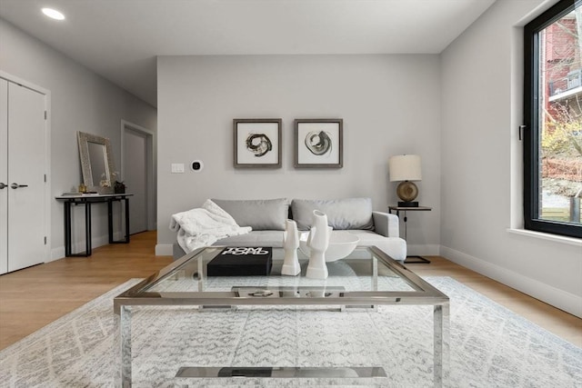 living area featuring baseboards, plenty of natural light, recessed lighting, and wood finished floors