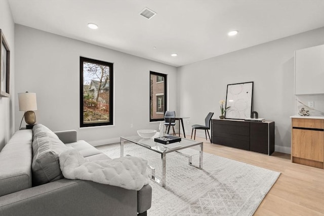 living area with recessed lighting, baseboards, visible vents, and light wood-type flooring