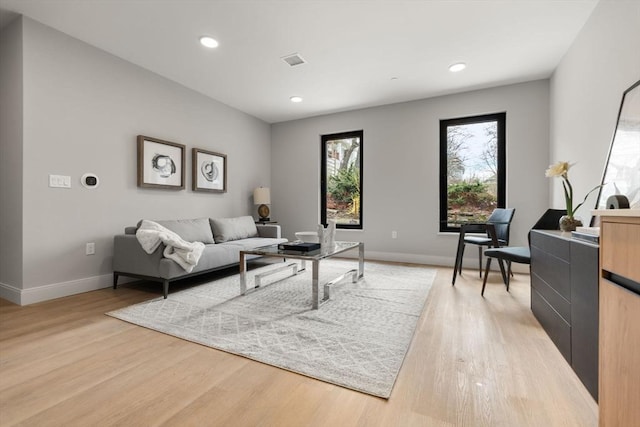 living room featuring recessed lighting, baseboards, visible vents, and light wood-style flooring