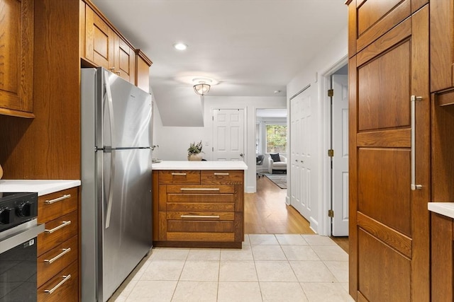 37 Symphony Rd Unit B, Boston, MA 02115 - kitchen featuring freestanding refrigerator, a peninsula, brown cabinetry, light countertops, and recessed lighting