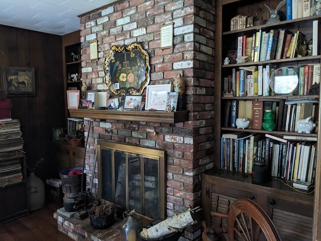 living room featuring brick wall, a brick fireplace, and hardwood / wood-style floors