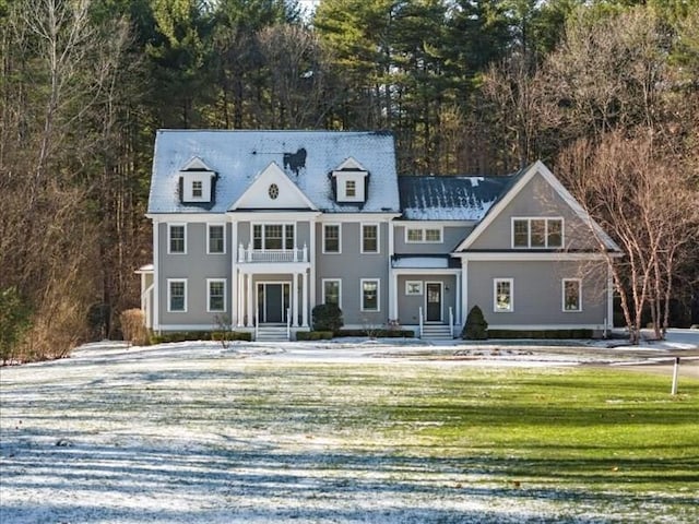 view of front of house featuring a balcony and a front yard