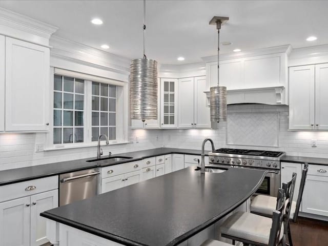 kitchen featuring stainless steel appliances, white cabinetry, sink, and pendant lighting