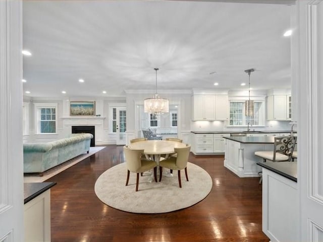 dining area featuring dark hardwood / wood-style flooring, crown molding, and sink