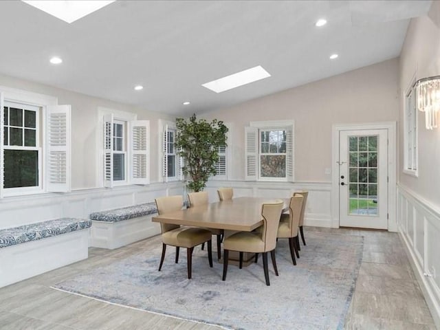 dining area with lofted ceiling with skylight